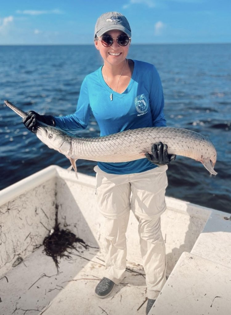 Makailyn Hernandez holding a gar during fieldwork